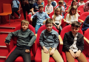 Dzieci siedzą na widowni, czekają na spektakl pt. "Calineczka".