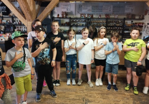 Dzieci uczestniczą w inscenizacji przedstawiającej dawny sposób wypieku pierników.