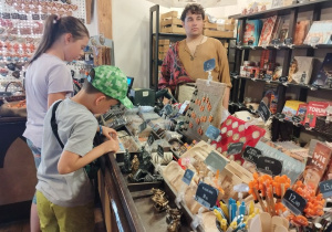 Uczniowie robią zakupy w sklepie z pamiątkami.