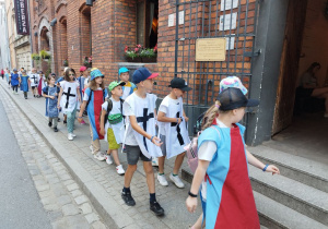 Grupa dzieci w średniowiecznych strojach.