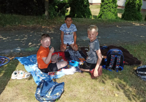 Uczniowie klasy I A biorą udział w pikniku na terenie szkoły.