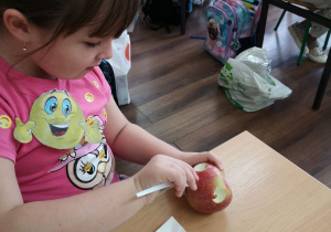 Dzieci rzeźbią uśmiechy w jabłkach