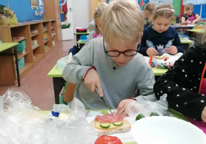 Dzieci przygotowują pysze i zdrowe kanapki z jajkiem i warzywami.