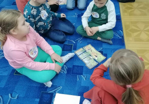 Dzieci układają puzzle z Bolkiem i Lolkiem.