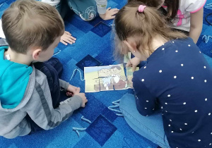 Dzieci układają puzzle z Bolkiem i Lolkiem.