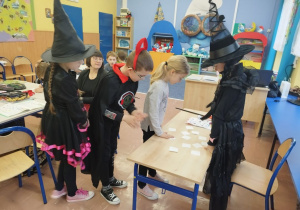 Uczennica w stroju czarownicy "przepowiada przyszłosć" za pomocą kart
