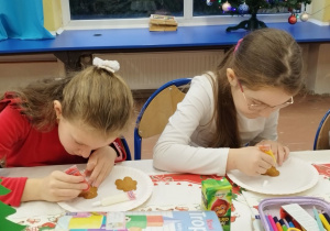 Dzieci ozdabiają pierniczki kolorowym lukrem