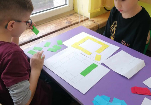 Dzieci układają domino matematyczne.