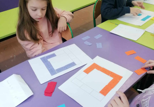 Dzieci układają domino matematyczne.