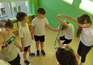Uczniowie klasy I B współpracują podczas ćwiczeń z obręczą.