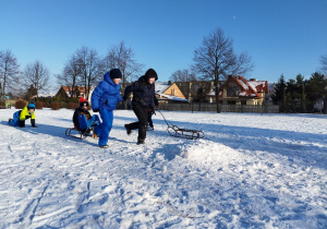 Zabawy na śniegu na boisku szkolnym - wyścigi saneczkowe.
