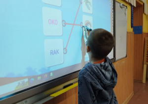 Uczeń rozwiązuje zadanie przy tablicy dotykowej
