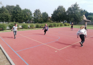 Pięcioro dzieci biega na boisku szkolym