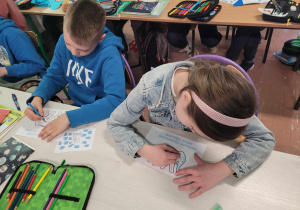 Dzieci kolorują obrazki związane z autyzmem w odcieniach niebieskiego