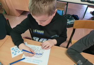 Dzieci kolorują obrazki związane z autyzmem w odcieniach niebieskiego
