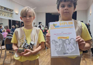 Chłopcy prezentują dyplomy i statuetkę.