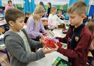 Dzieci uczą się pakować prezenty w pudełkach