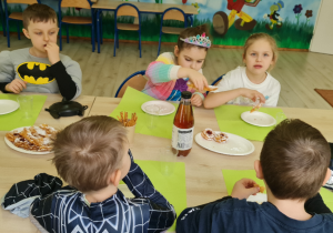 Dzieci próbują faworki i chrustowe róże.