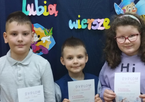Uczniowie z klasy 2 trzymają dyplomy za udział w szkolnym konkursie recytatorskim