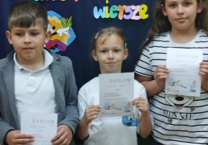 Uczniowie z klasy 2 trzymają dyplomy za udział w szkolnym konkursie recytatorskim