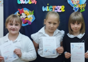 Uczniowie z klasy 1 trzymają dyplomy za udział w szkolnym konkursie recytatorskim