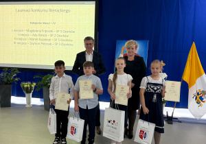 Laureaci konkursu literackiego prezentują dyplomy i nagrody