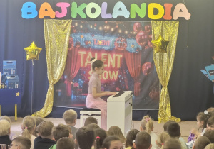 Uczennica klasy 3 gra na pianinie.