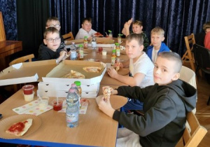dzieci jedzą pizzę po treningu