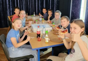 dzieci jedzą pizzę po treningu