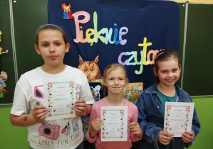 Uczniowie z klasy 2b trzymają dyplomy za udział w szkolnym konkursie "Pięknie czytam".