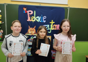 Uczniowie z klasy 3a trzymają dyplomy za udział w szkolnym konkursie "Pięknie czytam".