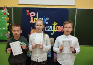Uczniowie z klasy 3c trzymają dyplomy za udział w szkolnym konkursie "Pięknie czytam".