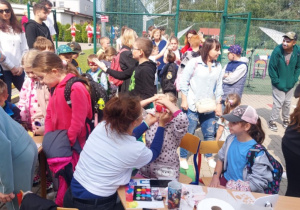 Dzieci malują twarze i naklejają tatuaże