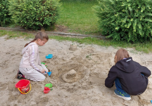 Dziewczynki budują elementy stacji.