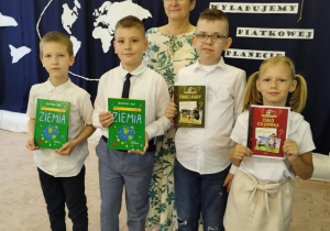 Uczniowie i pani dyrektor z nagrodami i dyplomami